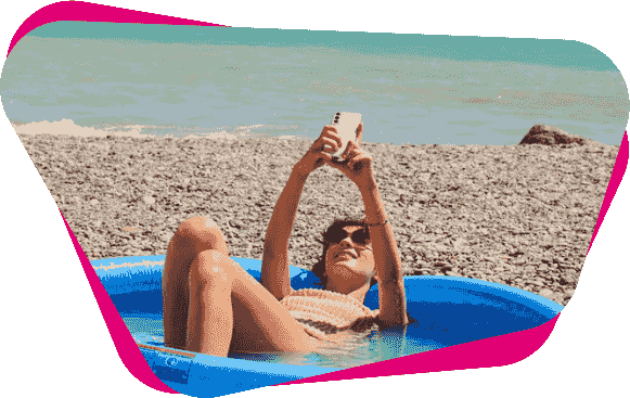 Mobiles WLAN: Frau liegt mit einem Handy in der Sonne am Strand in einem Pool